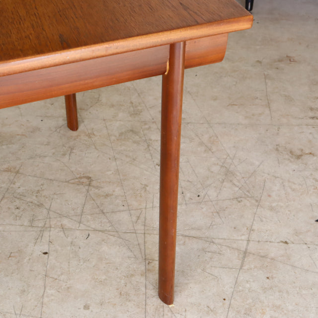 Mid-century British vintage teak dining table with smooth wood grain and tapered legs.
