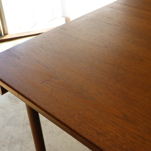 Mid-century British vintage teak dining table with smooth wood grain and rounded legs from Whiteandnewton.