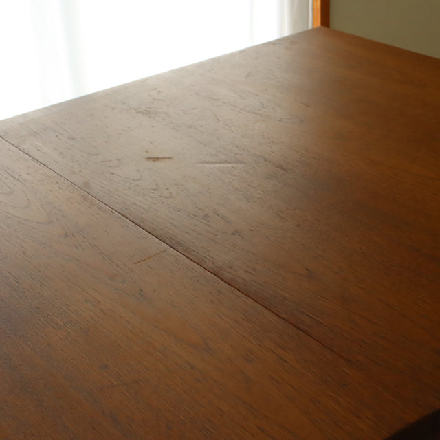 Vintage British mid-century teak dining table with smooth wood grain and clean rectangular surface.