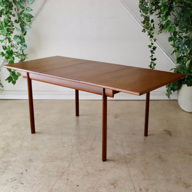Vintage British mid-century teak dining table by Whiteandnewton with clean rectangular top and slender round legs.