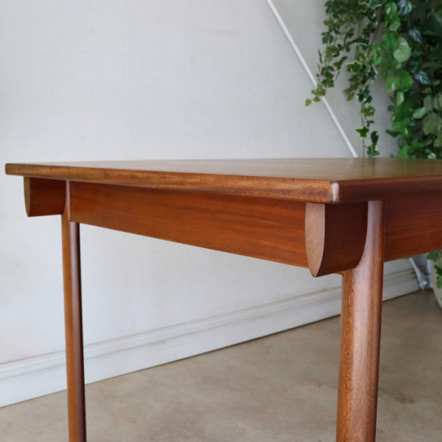 Mid-century British vintage teak dining table by Whiteandnewton with smooth wood grain and rounded legs.