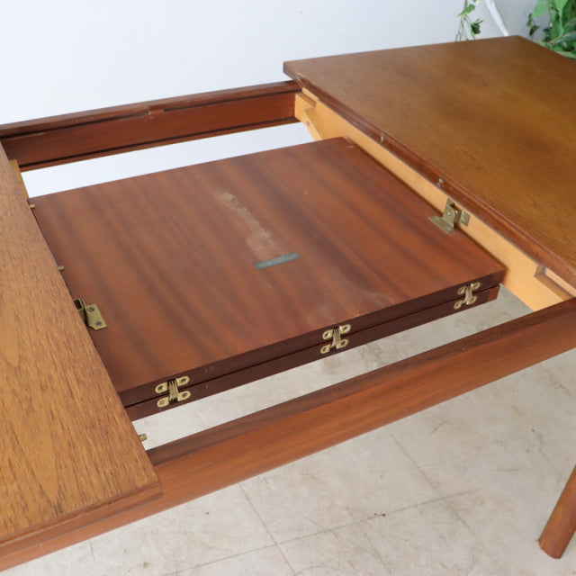 Mid-century British teak dining table by Whiteandnewton with visible wood grain and extension mechanism.
