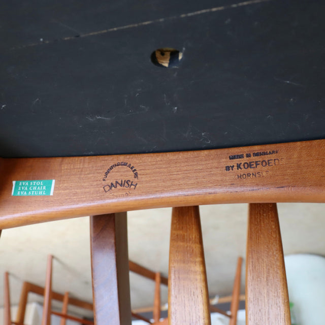 Close-up of teak wood frame from vintage Danish KOFOEDS HORNSLET mid-century dining chair showing natural wood grain, curved .