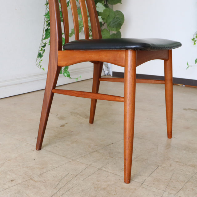 Set of two vintage mid-century Danish dining chairs by Koefoeds Hornslet, featuring teak wood frames with visible grain,.