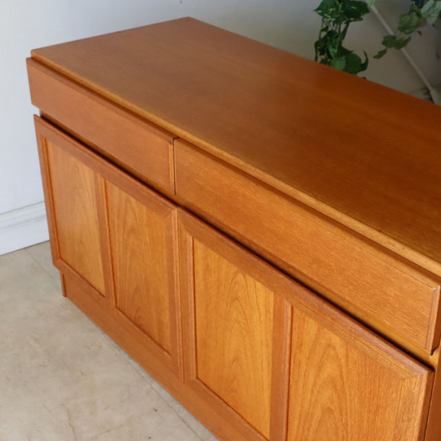 Vintage British McIntosh mid-century teak sideboard with rich wood grain, clean lines, and tapered legs.