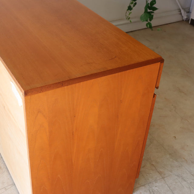 Mid-century British McIntosh teak sideboard with smooth wood grain, clean lines, and rounded edges, showcasing vintage.