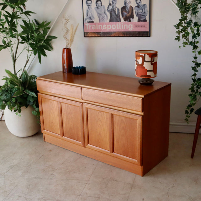 British mid-century McIntosh teak sideboard with smooth wood grain, clean lines, and recessed panel doors.