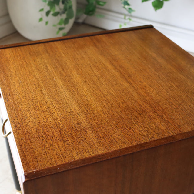 Vintage British teak bedside cabinet with smooth wood grain finish and clean mid-century lines.