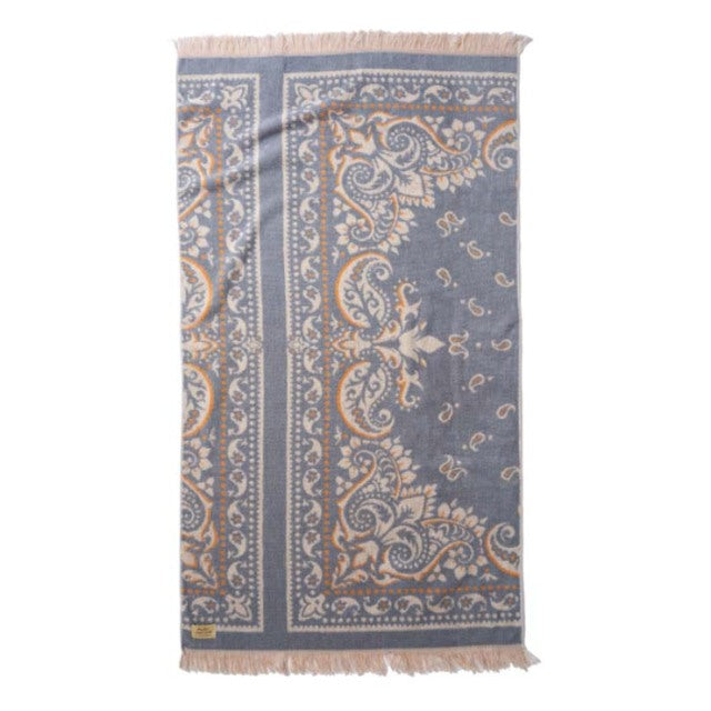 Mid-century British vintage cotton pile blanket in sax blue with intricate bandana paisley pattern and fringed edges.