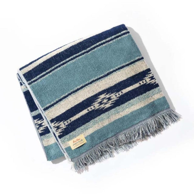 Vintage British cotton pile blanket with native border pattern in blue, teal, and cream, fringed edges, small Basshu brand.