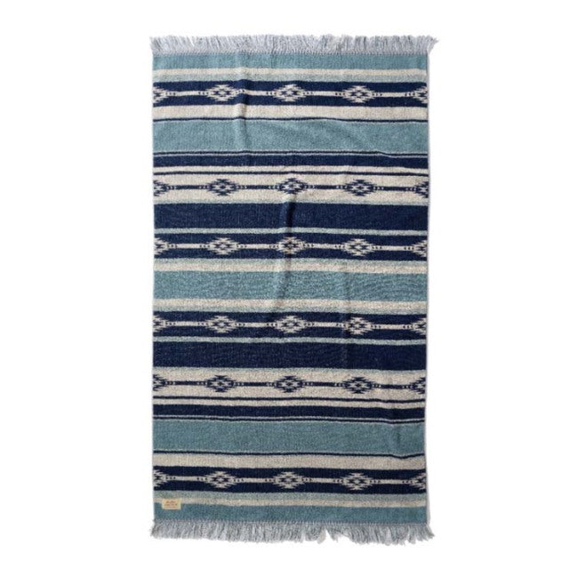 Blue and navy cotton pile blanket with native border pattern and fringed edges, vintage style.