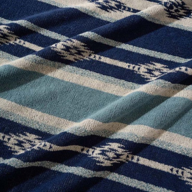 Blue and beige cotton pile blanket with vintage native border pattern, soft textured fabric.
