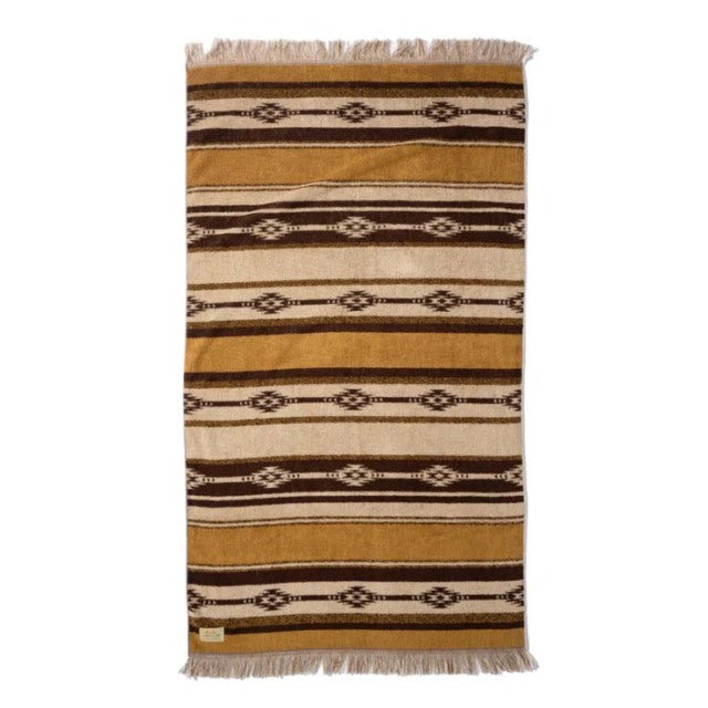 Brown and beige cotton pile blanket with native border pattern and fringed edges.