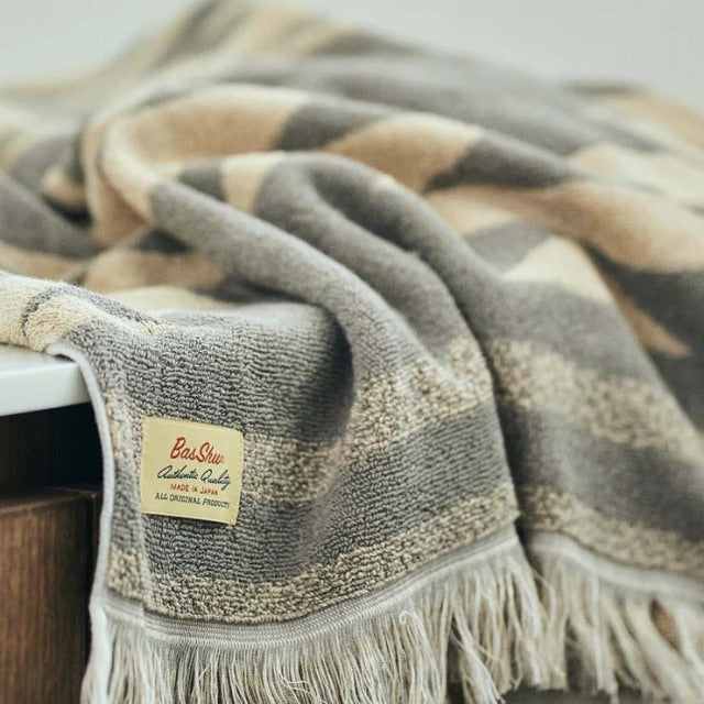 Beige cotton pile blanket with native motif, fringed edges, soft texture, vintage British style.