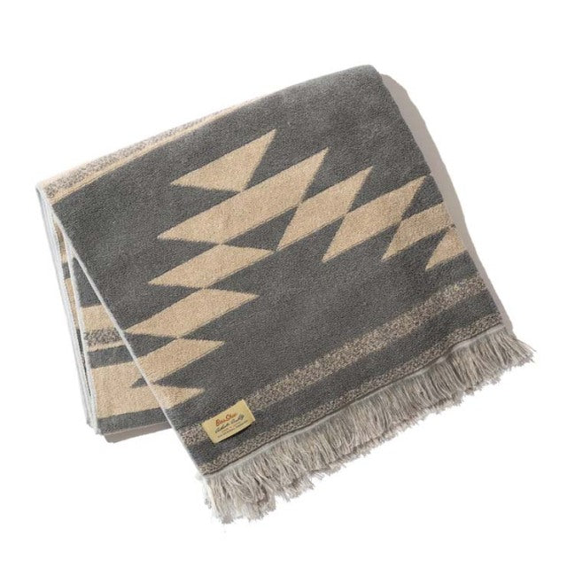 Beige cotton pile blanket with native geometric motifs and fringed edges, vintage British style.
