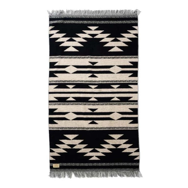 Black and white vintage cotton pile blanket with Native American-inspired geometric patterns and fringe edges, perfect for.