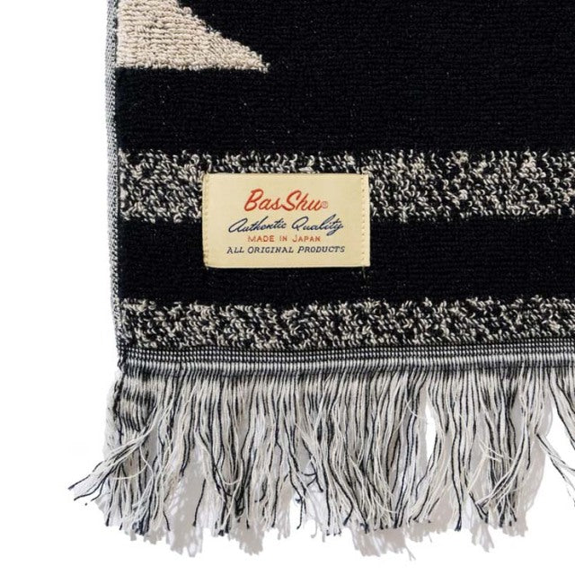 Black and gray cotton pile blanket with native motif, fringed edges, and Basshu label on vintage textile.