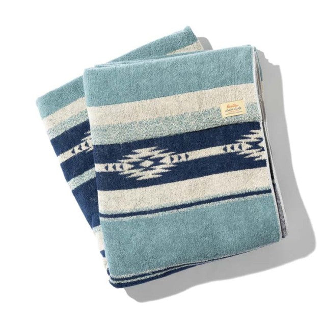 Blue cotton pile blanket with native border pattern, vintage style, soft texture, folded flat.