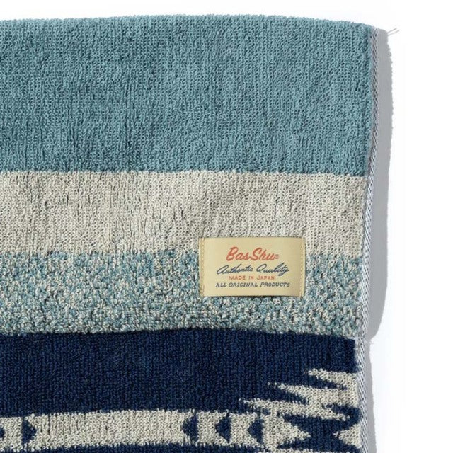 Blue and beige vintage cotton pile blanket with native border pattern and Basshu brand label.