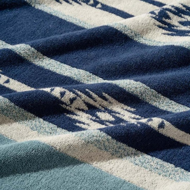 Blue and cream cotton pile blanket with Native border pattern, textured vintage style textile.