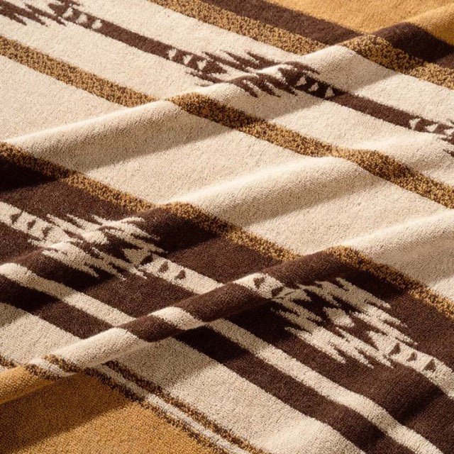 Brown and cream cotton pile blanket with native border pattern, vintage British style, soft texture.