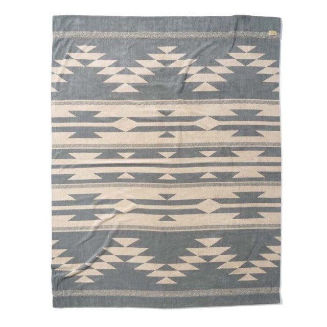 Beige and gray cotton pile blanket with native geometric patterns, vintage British style, soft texture.