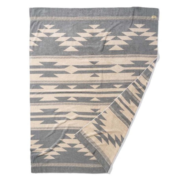 Beige cotton pile blanket with Native American-inspired geometric patterns in gray and cream, folded to show soft texture.