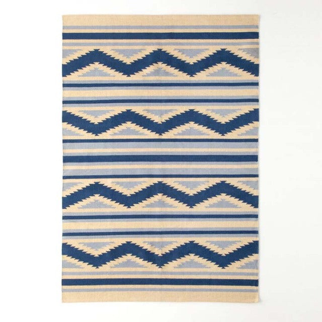 Vintage cotton rug with geometric zigzag patterns in navy blue and cream, inspired by mid-century British and Danish design.
