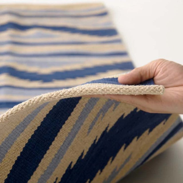 Handwoven vintage cotton rug with blue and beige geometric pattern, showcasing textured weave and soft edges, complementing.