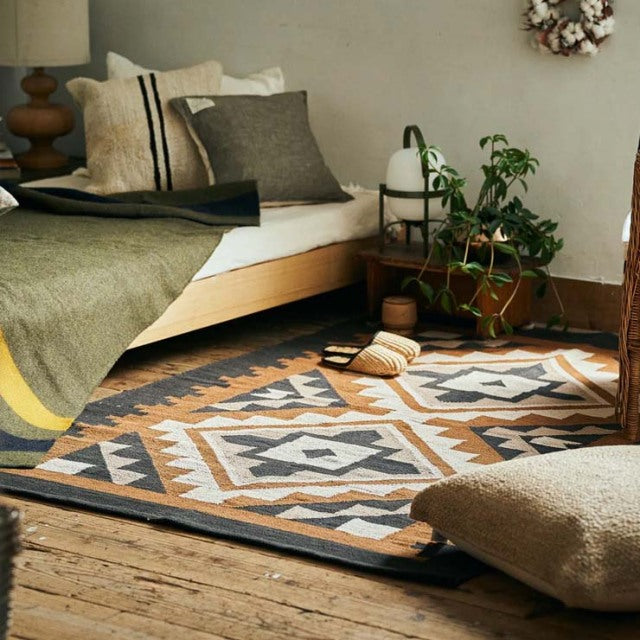 Mid-century teak bed frame with clean lines paired with a British-Denmark vintage cotton rug featuring geometric patterns in .