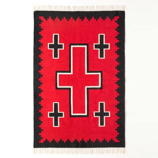 Vintage mid-century style cotton rug with bold red and black geometric cross patterns, framed by fringe edges.