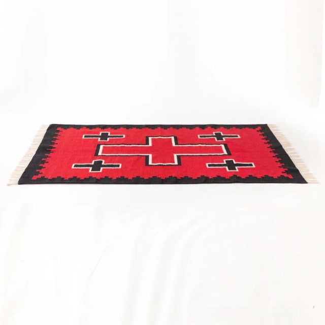 Vintage mid-century British cotton rug with bold red, black, and white geometric pattern, fringed edges, and flat weave.