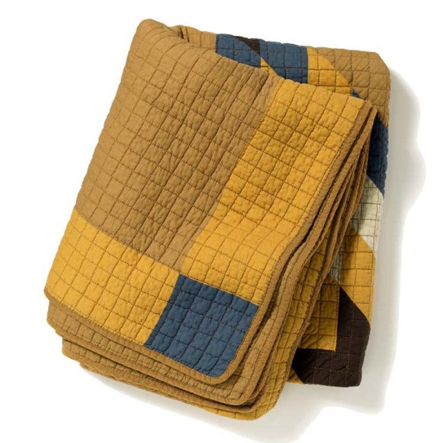 Vintage patchwork quilt cover in camel tones with mustard, navy, and brown squares, featuring detailed quilting and soft.
