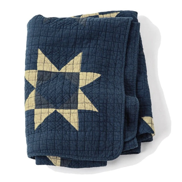 Blue patchwork quilt cover with beige star pattern, textured stitching, vintage British style.