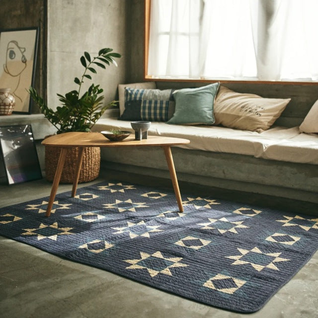 Mid-century British teak coffee table with tapered legs on blue patchwork quilt rug by Basshu, vintage style.