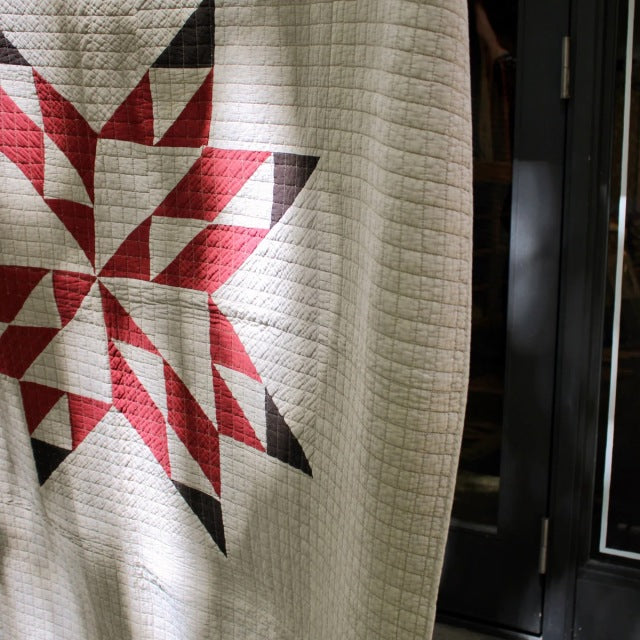 Beige patchwork quilt cover with a vintage star pattern in red, black, and brown tones, featuring detailed stitching.