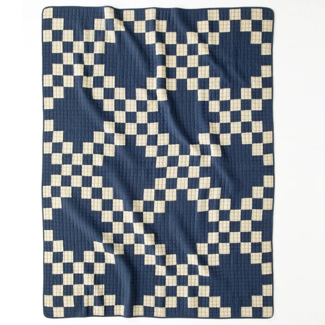 Navy and cream patchwork quilt cover with vintage British mid-century design, intricate geometric pattern, soft textured.