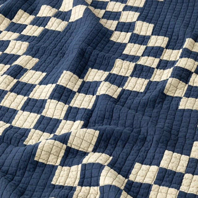 Navy and cream patchwork quilt cover with textured stitching, evoking vintage British and mid-century Denmark style.