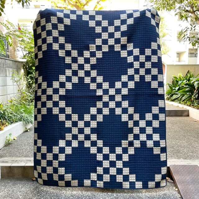 Navy and cream patchwork quilt cover with vintage-inspired geometric pattern, textured cotton fabric.
