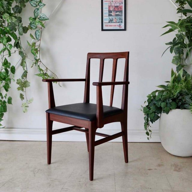 Vintage teak mid-century dining chair by Younger, British design with armrests, sleek wood grain and black cushioned seat,.