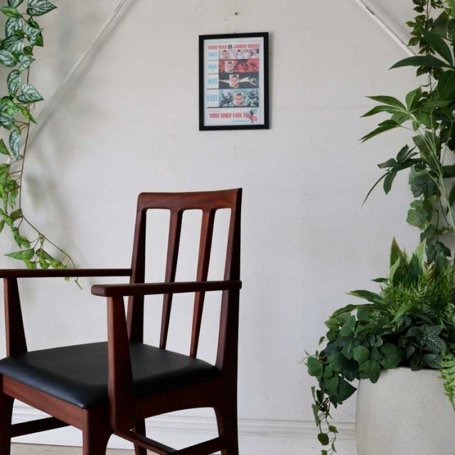 Vintage teak dining chair with armrests, British mid-century design by John Herbert, sleek vertical slats and tapered legs.