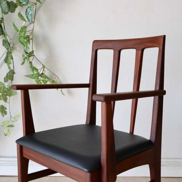 Vintage mid-century teak dining chair by Younger with British design, featuring black cushioned seat, slender vertical back.