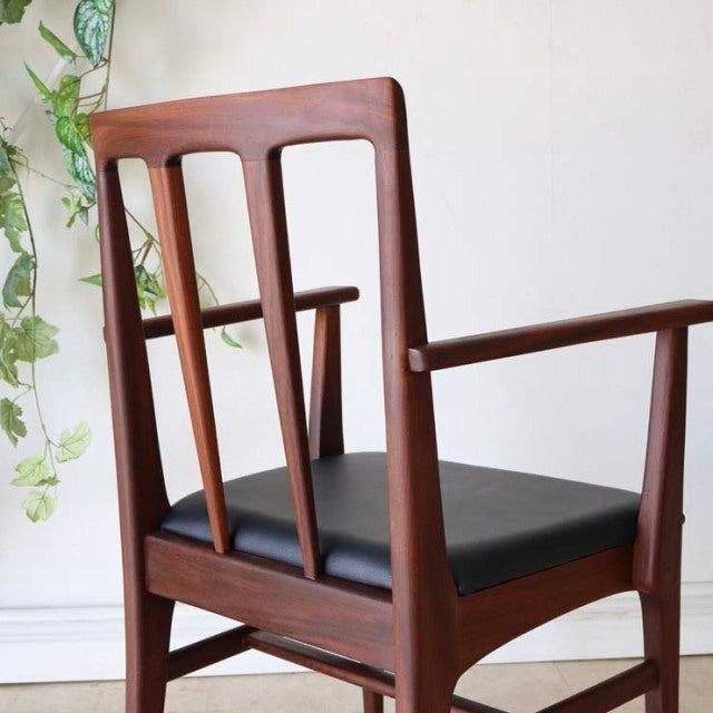 Vintage British teak dining chair by Younger with mid-century design, sleek armrests, and black cushioned seat, showcasing.