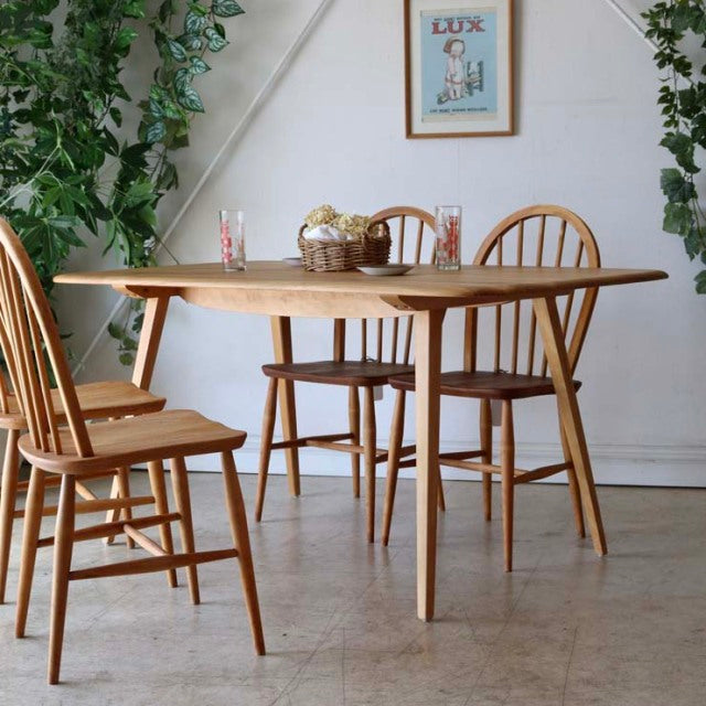 Vintage British Ercol mid-century teak dining table with rounded rectangular top, tapered legs, and natural wood grain,.