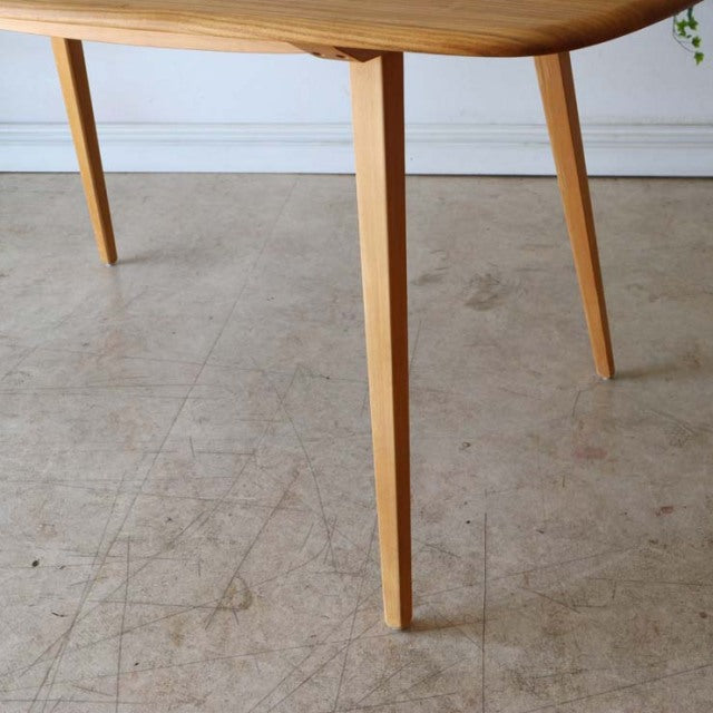 Mid-century British Ercol dining table in vintage teak with tapered legs and smooth wood grain finish.