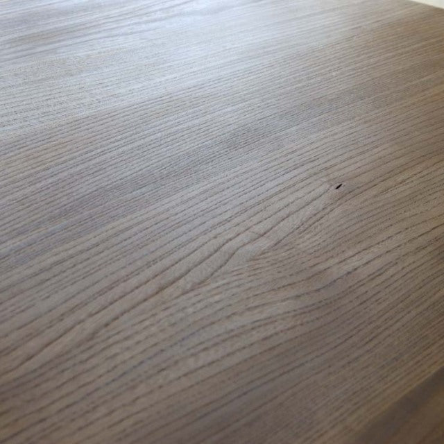 Close-up of vintage British mid-century teak dining table top showing fine wood grain and smooth finish.