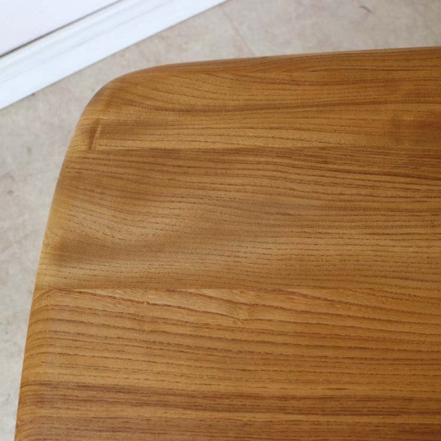 Mid-century British vintage Ercol dining table in teak with smooth wood grain and rounded corner edges.