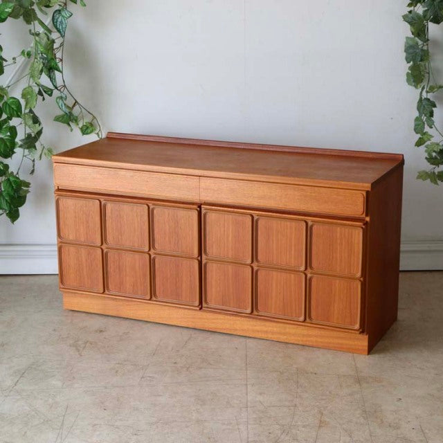 Mid-century British McIntosh sideboard in vintage teak with paneled front and clean wood grain, slender legs, simple.