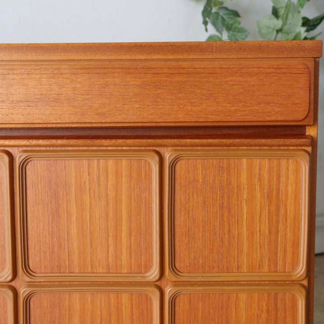 Mid-century British McIntosh teak sideboard with detailed wood grain, rounded drawer fronts, and clean-lined legs in vintage .