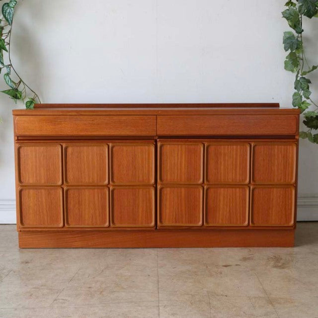 Mid-century British vintage teak sideboard by McIntosh with geometric carved panel doors and tapered legs.